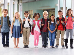 Group of elementary school kids standing in school corridor