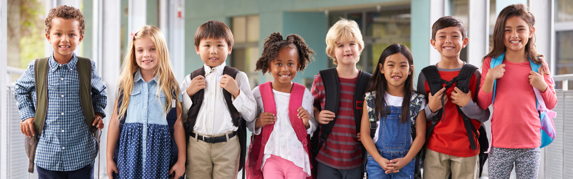 Group of elementary school kids standing in school corridor