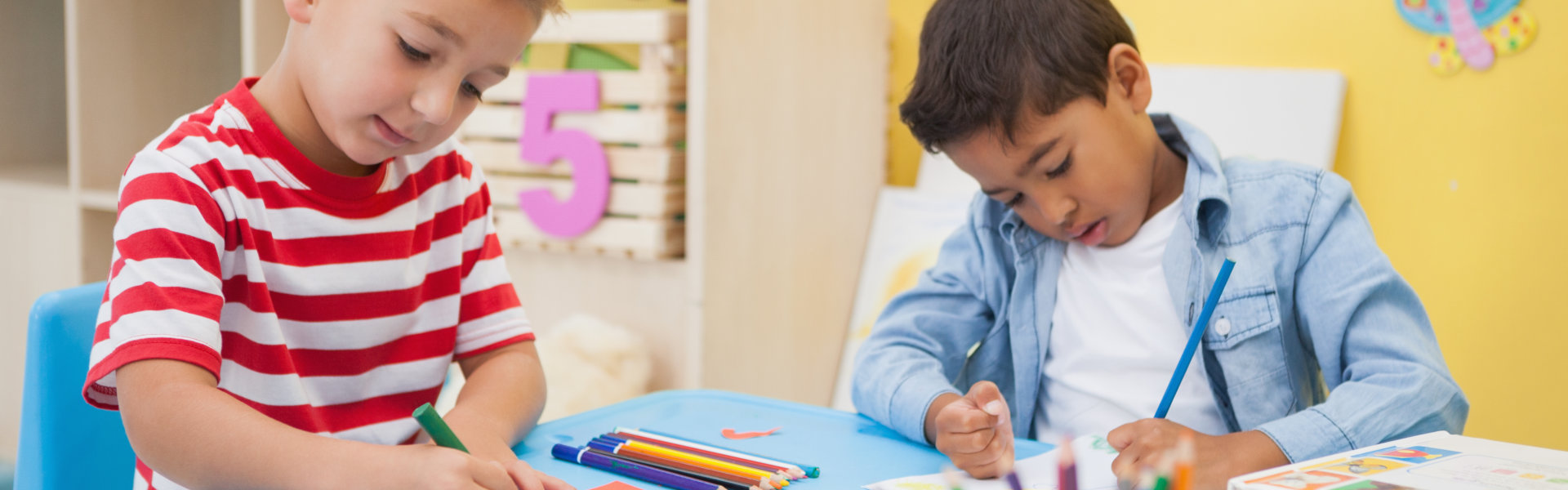 Cute little boys making art together in classroom at the nursery school